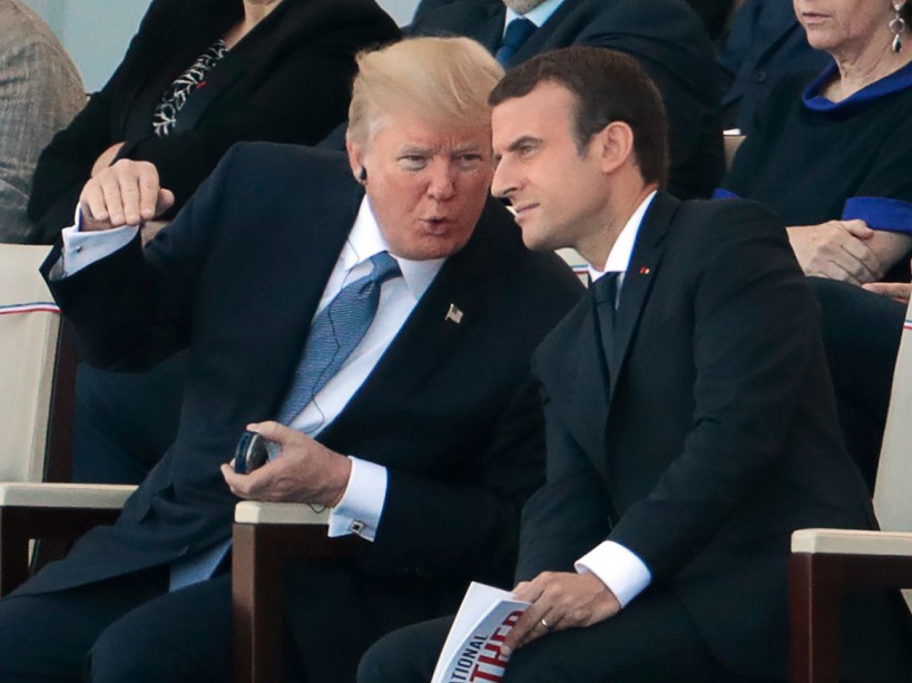 French President Emmanuel Macron (R) listens to US President Donald Trump as they attend the annual Bastille Day military parade on the Champs-Elysees avenue in Paris on July 14, 2017. The parade on Paris's Champs-Elysees will commemorate the centenary of the US entering WWI and will feature horses, helicopters, planes and troops. / AFP PHOTO / joel SAGET